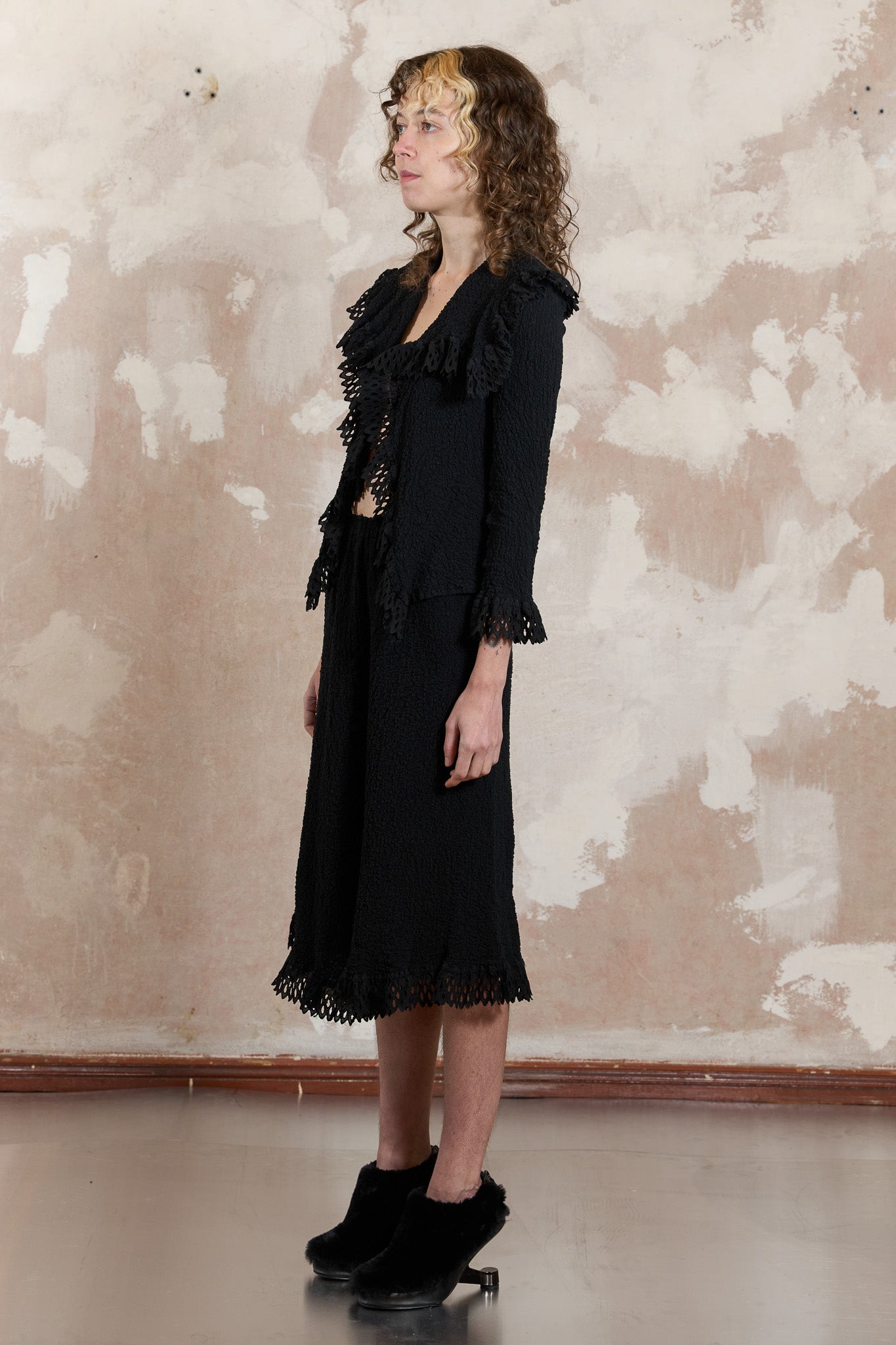 Rare blazer and skirt set tailored from black pleated fabric finished with doily ruffles 2008